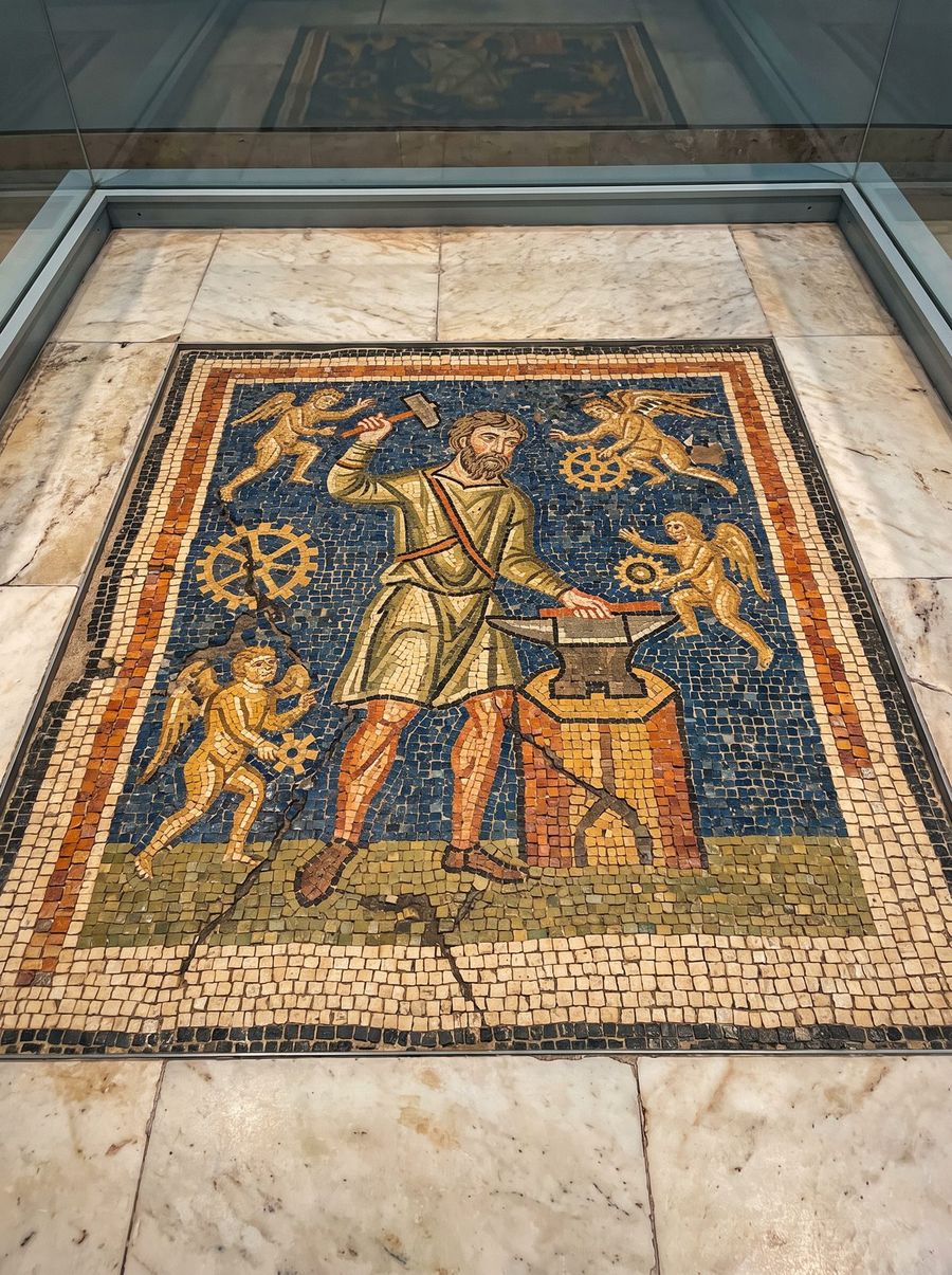 Ancient mosaic of Hephaestus at his forge with golden automatons